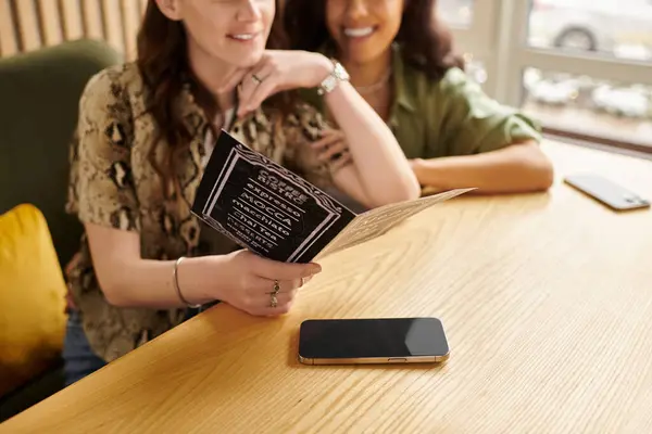 Two women share a delightful moment at their favorite cafe, immersed in conversation and smiles. — Stock Photo