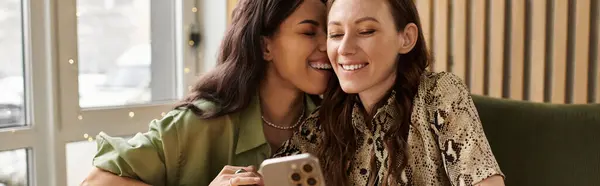 Two women share laughter and affection while taking selfies at a charming cafe. — Stock Photo