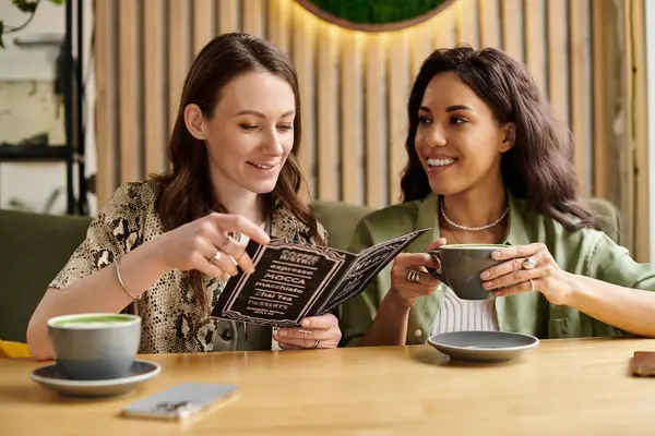 A couple enjoys each others company at a cafe, eagerly looking through the menu and smiling — Stock Photo