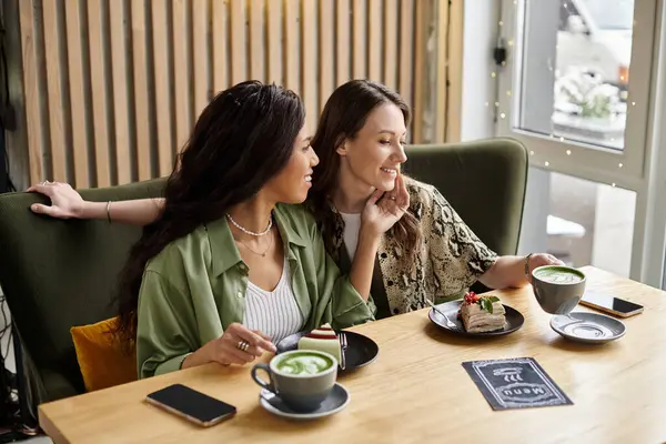 Two women share delicious treats and connect deeply over coffee, basking in their affection. — Stock Photo