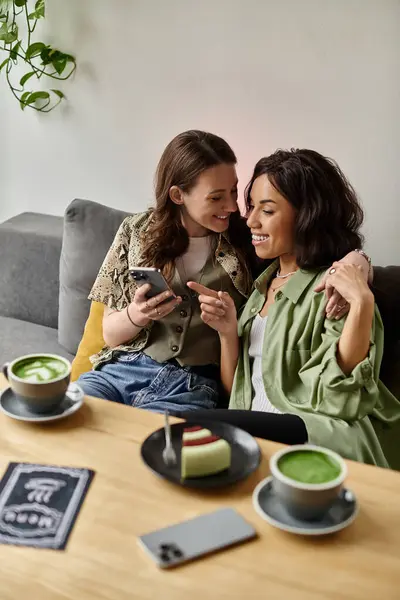 Two women sit close together in a cozy cafe, sharing laughter and enjoying each others company. — Stock Photo