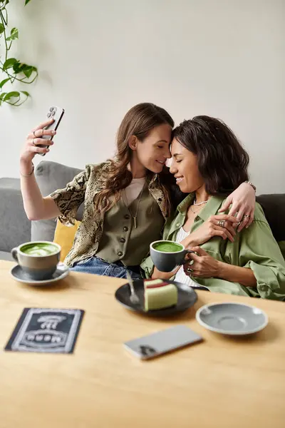 Two women savor drinks and desserts, capturing a joyful moment together. — Stock Photo