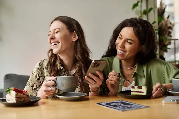 A lesbian couple shares laughs over coffee and dessert at a cafe, enjoying a happy moment. — Stock Photo