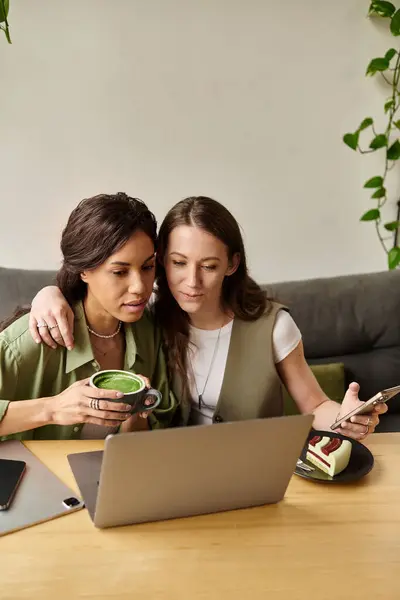 Two women share a moment at a cafe, sipping drinks and enjoying each others company. — Stock Photo
