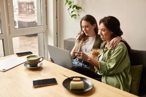 Lesbian couple sits closely at a cafe, sharing laughter and conversation over drinks and dessert. — Stock Photo