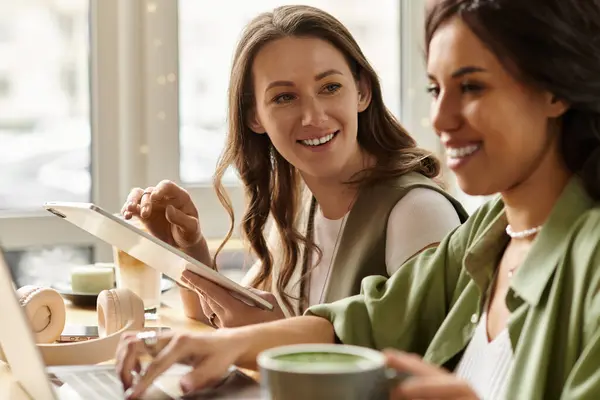 Two women enjoy their time at a charming cafe, engaging in light hearted conversation and laughter. — Stock Photo