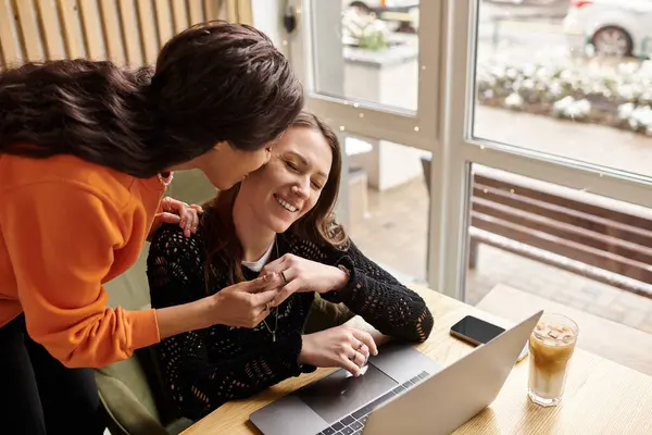 Two women enjoy their time together, sharing laughter and affection at a warm cafe. — Stock Photo