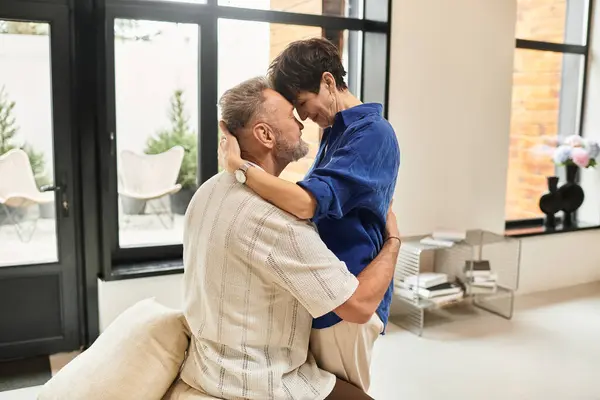 A joyful couple embraces each other in their cozy home, radiating love and warmth together. — Stock Photo