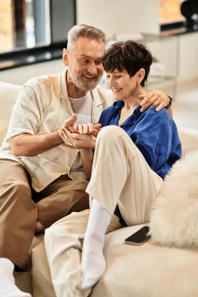 Ein Ehepaar entspannt sich zu Hause, lächelt und lacht gemeinsam. — Stockfoto