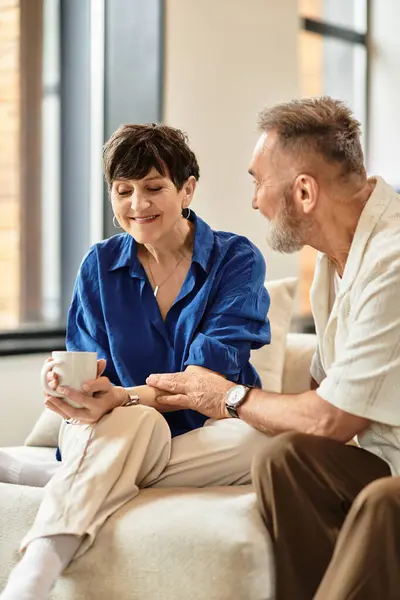 A delighted couple enjoys each other's company while sipping coffee at home. — Stock Photo