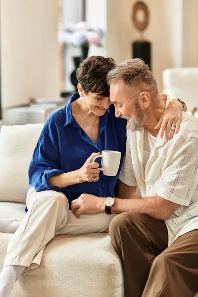 Middle aged couple share a tender moment while smiling and relaxing at home together. — Stock Photo