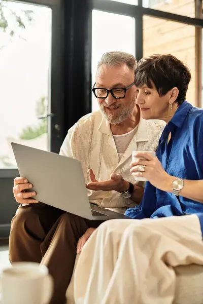 Happy couple shares a joyful moment at home, discovering new interests on their laptop. — Stock Photo