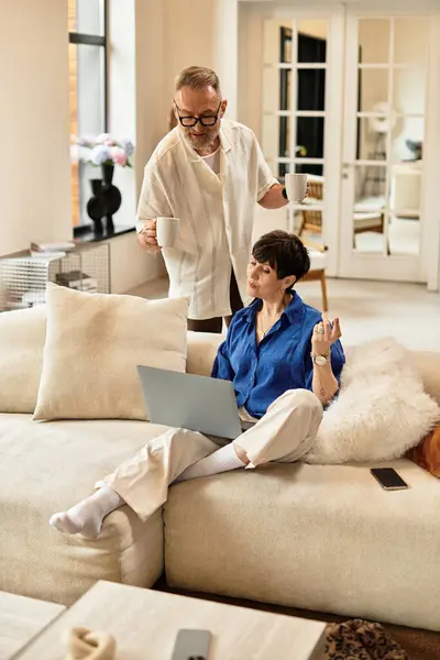 A cheerful middle-aged couple enjoys their time at home while engaged in a casual activity. — Stock Photo
