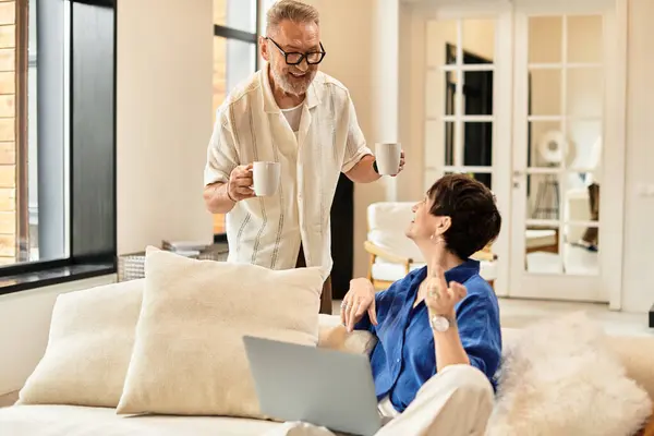 A cheerful couple enjoys coffee together while engaging in lively conversation at home. — Stock Photo