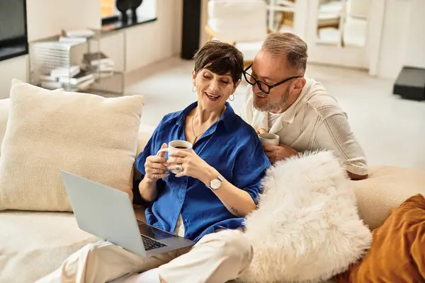 A joyful husband leans in, sharing a lighthearted moment with his wife as they sip coffee. — Stock Photo
