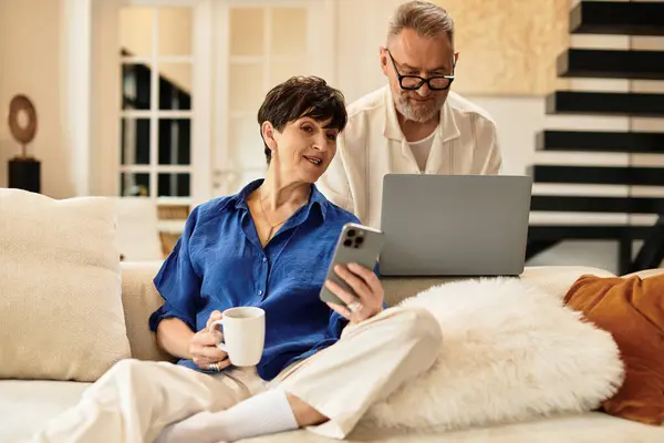 A middle aged couple enjoys quality time together, sharing smiles and a warm drink. — Stock Photo