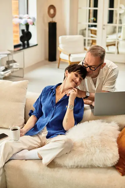 Una coppia gioiosa si gode la compagnia mentre lavora insieme su un computer portatile. — Foto stock