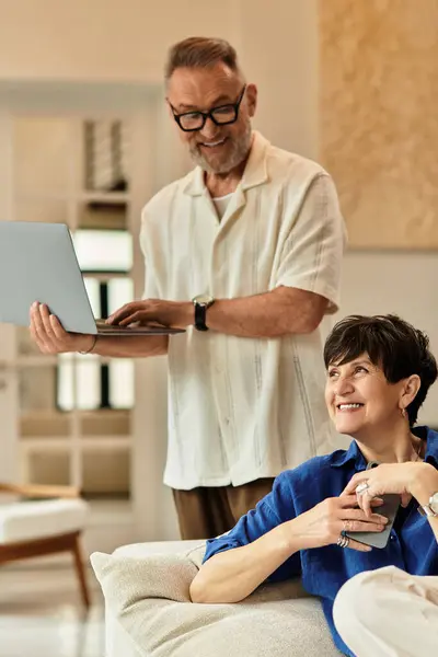A happy couple enjoys each other's company while relaxing at home, engaging in personal tasks. — Stock Photo