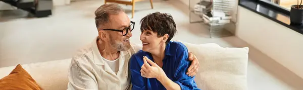 A husband and wife exchange smiles and laughter while enjoying their cozy living space, banner — Stock Photo