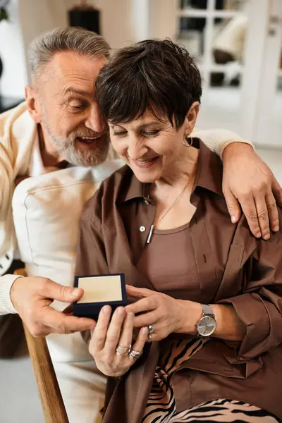 Joyful husband and wife enjoy a heartfelt moment at home while exchanging a thoughtful present. — Stock Photo
