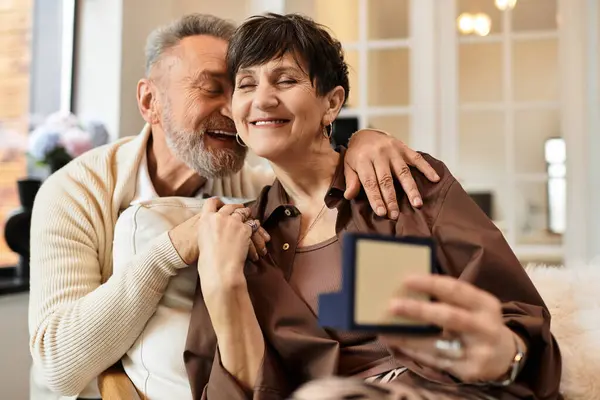 Couple shares laughter and love in their cozy home setting, man gifting his wife — Stock Photo