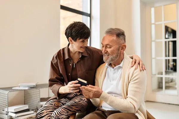 A joyful couple enjoys each other's company while reminiscing in their inviting home setting. — Stock Photo