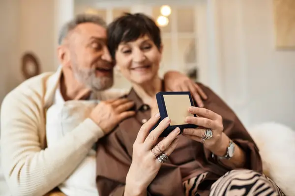 Una pareja casada disfruta de un momento sincero juntos mientras están en casa, apreciando un regalo sorpresa. — Stock Photo