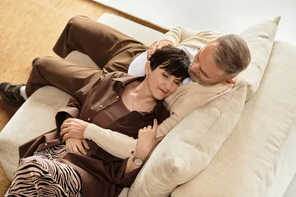 A happy couple enjoys quality time on their cozy couch, reflecting their strong bond and love. — Stock Photo