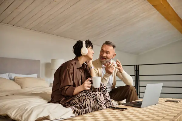 A middle aged couple shares laughter and warmth while relaxing at home together. — Stock Photo