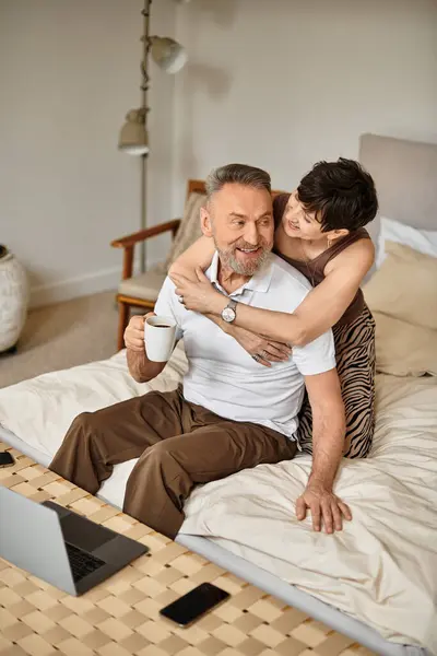 Middle aged husband and wife share a peaceful moment on their bed, enjoying each other's company. — Stock Photo