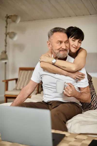 Un mari et une femme d'âge moyen qui aiment partager chaleur et rire dans leur chambre confortable. — Photo de stock