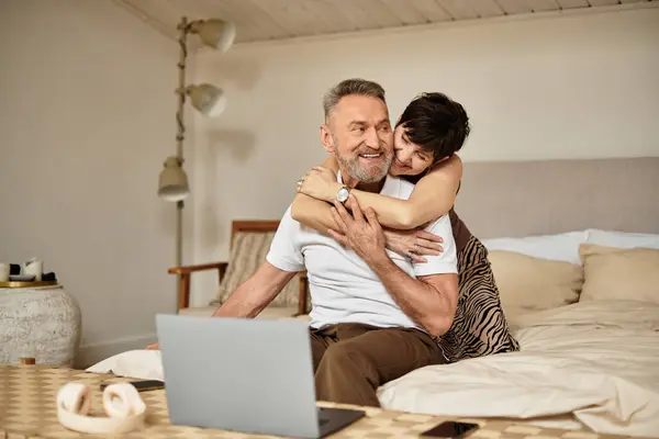 Um casal de meia-idade desfruta de um abraço caloroso enquanto relaxa juntos em casa. — Fotografia de Stock