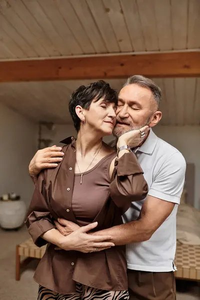 Una coppia sorridente abbraccia in una casa calda e accogliente, irradiando amore e felicità. — Foto stock