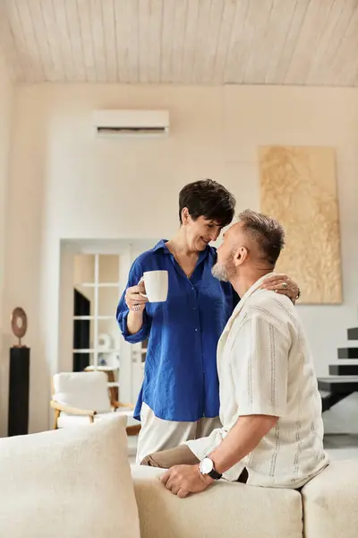 A happy middle aged couple enjoys each other's company at their cozy home, sharing laughter. — Stock Photo