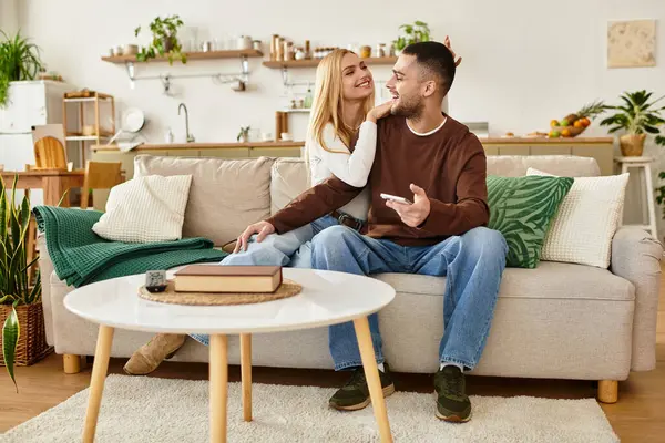 A couple relaxes on their sofa, sharing smiles and laughter together. — Stock Photo