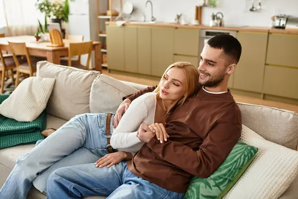 A couple cuddles on a soft couch in their cozy, inviting home. — Stock Photo