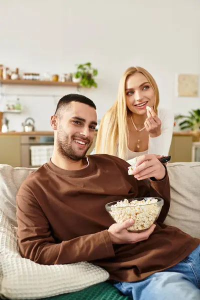 Ein Liebespaar teilt freudige Momente auf der Couch, genießt Popcorn und Gesellschaft voneinander. — Stockfoto