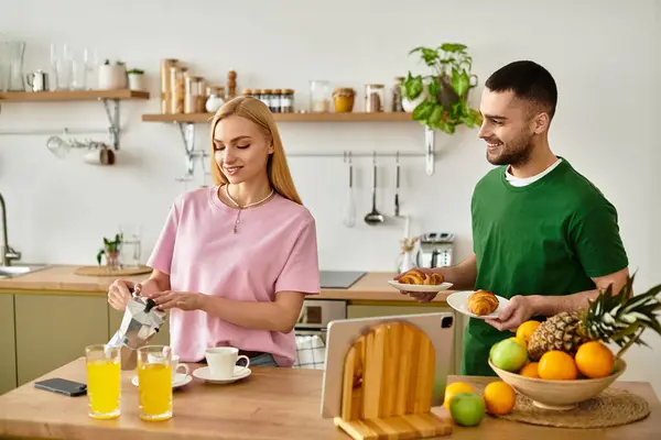 Un couple profite d'une matinée confortable à la maison, faire le petit déjeuner et savourer l'autre compagnie. — Photo de stock