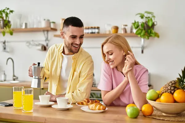 Joyful couple shares a delightful breakfast moment while laughing and enjoying the morning light. — Stock Photo