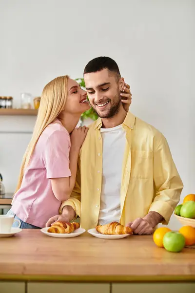 Loving couple shares laughter and affection while savoring breakfast at home together. — Stock Photo