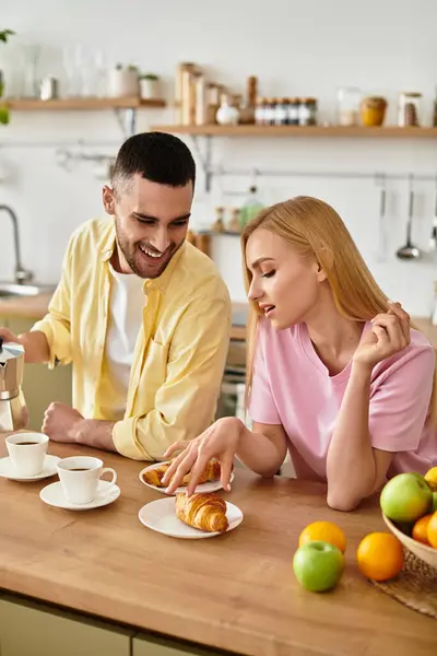 A man and woman share a delightful morning, laughing and savoring fresh pastries and coffee. — Stock Photo