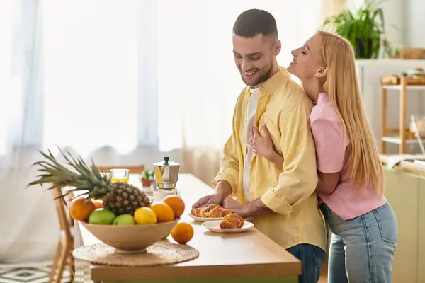 A man and woman enjoy a tender moment together, surrounded by fresh fruit, as they share breakfast. — Stock Photo