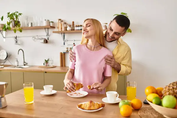 Una coppia condivide sorrisi e momenti teneri durante una deliziosa colazione nella loro accogliente cucina. — Foto stock