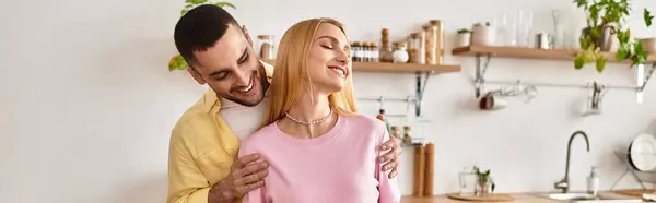 A couple shares warmth and affection in their bright kitchen together. — Stock Photo
