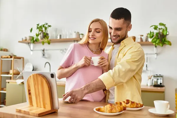 A couple shares a delightful morning moment with croissants and coffee, radiating happiness. — Stock Photo