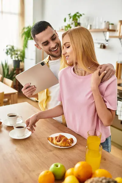 Couple enjoys breakfast together, sharing smiles and affection in a bright and cheerful kitchen. — Stock Photo