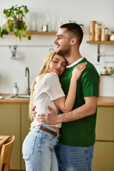 Ein Paar genießt eine herzerwärmende Umarmung in seiner charmanten Küche voller Wärme und Zuneigung. — Stockfoto