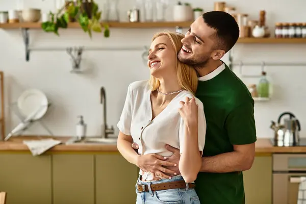 A loving couple shares a tender embrace in their stylish kitchen, filled with warmth and laughter. — Stock Photo