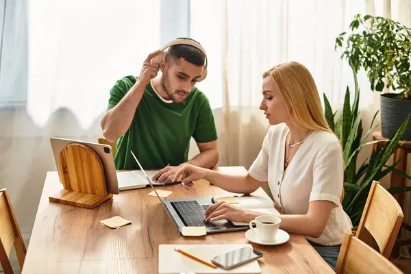 Couple enjoys quality time together at home, engaged in a collaborative work session while smiling. — Stock Photo