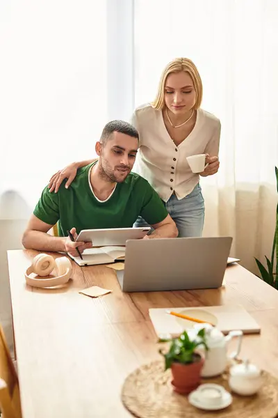 A couple shares a warm moment in their cozy home as they explore something together on a laptop. — Stock Photo